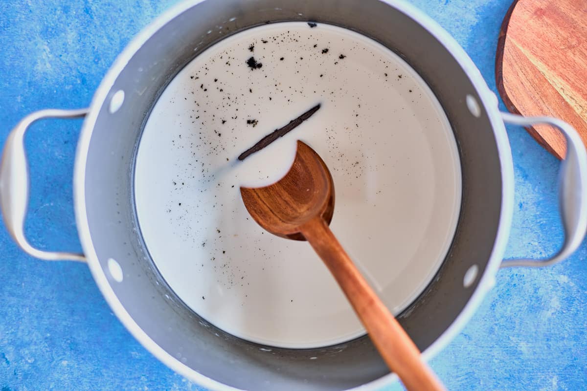 mixed wet ingredients, with an added vanilla bean for chestnut puree in a pot with a mixing spoon