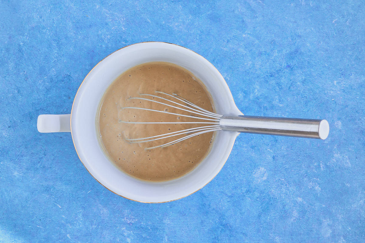 wet cake batter ingredients that have been mixed together in a bowl with a whisk