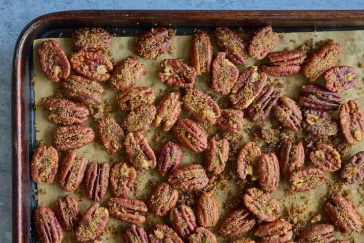 a baking sheet with nuts toasted in spice mixture