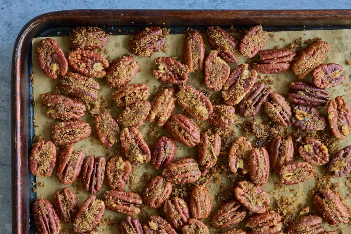 a baking sheet with pecans toasted in spice mixture