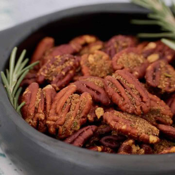 a close-up photo of finished pecans with rosemary sprigs