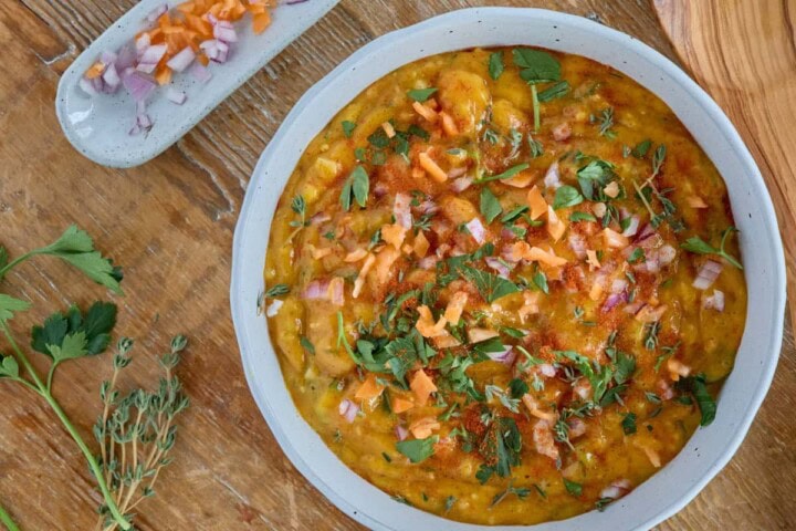 close-up photo of mango yassa sauce with extra garnishes on the side