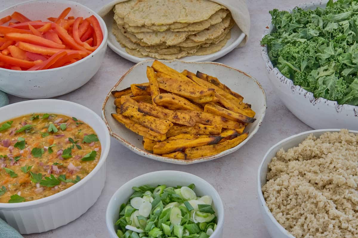 ingredients for the wraps, each in separate bowls, with a napkin to the side