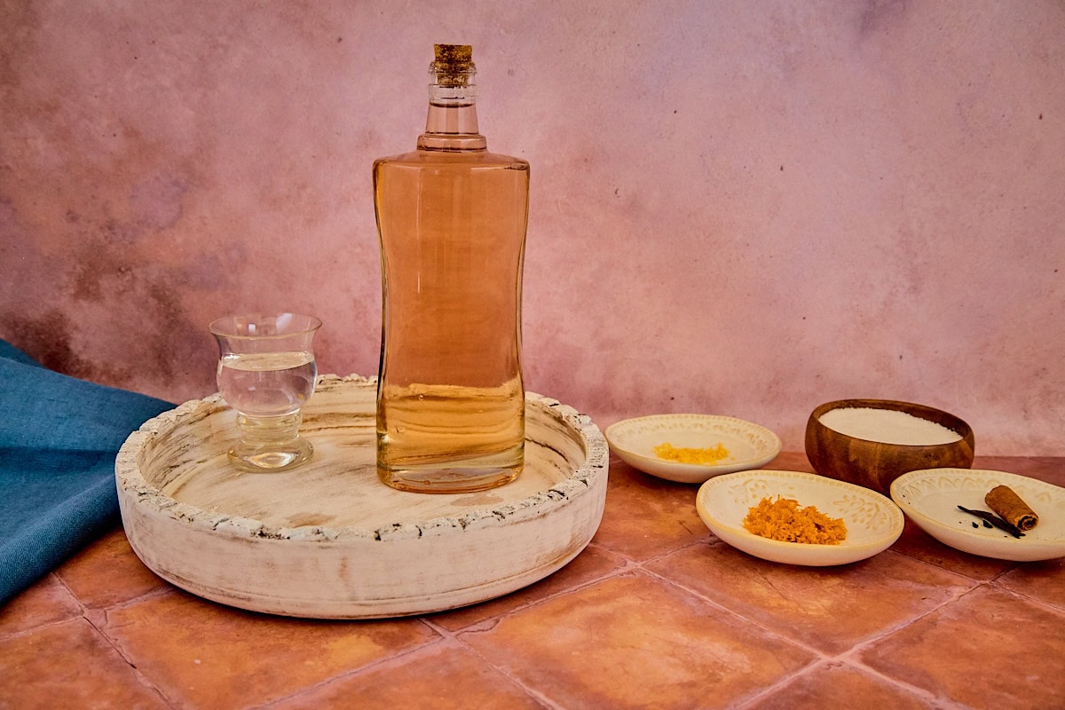 alcohol on a tray, citrus zest, sugar, and spices for version 2 of the vin d'orange, with a napkin in the background