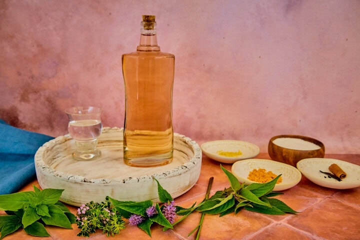 fresh herbs, alcohol on a tray, citrus zest, sugar, and spices for version 6 of the vin d'orange, with a napkin in the background