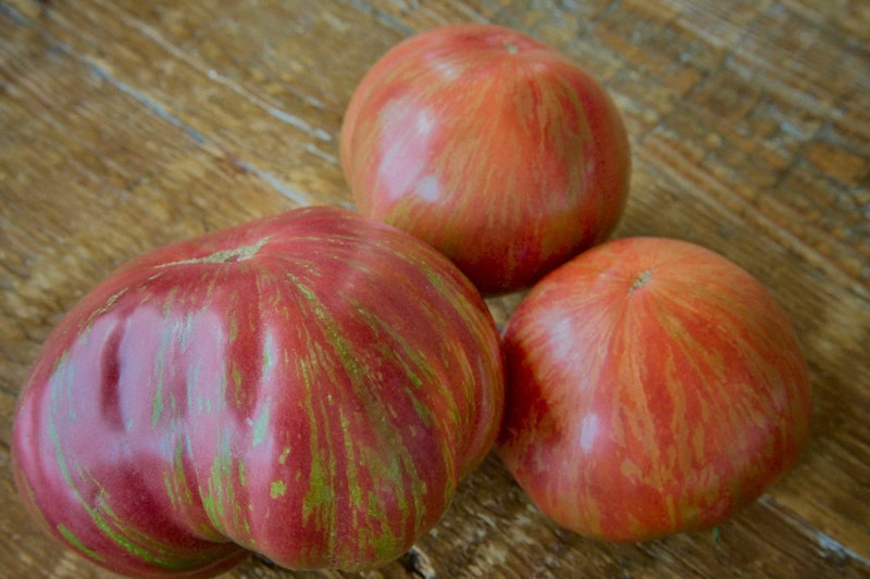 3 beauty king heirloom tomatoes on a rustic table