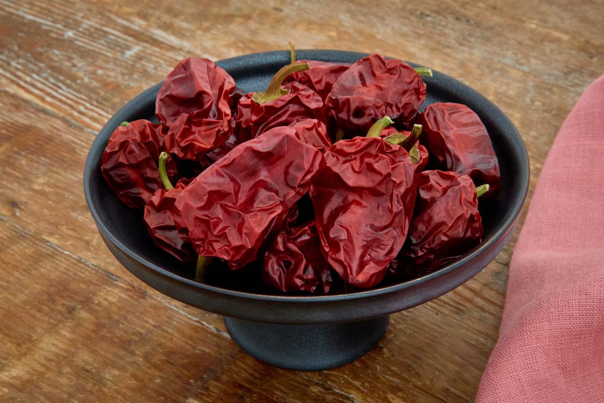 dried aleppo peppers in a footed dish with a napkin alongside
