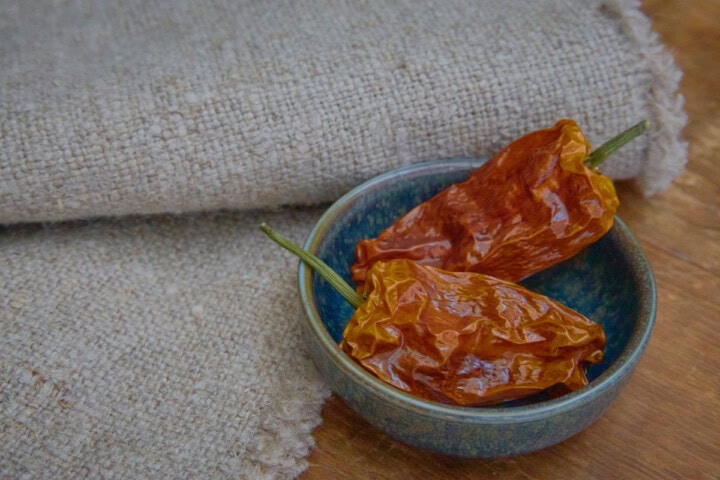 dried datil peppers in a bowl with a napkin alongside