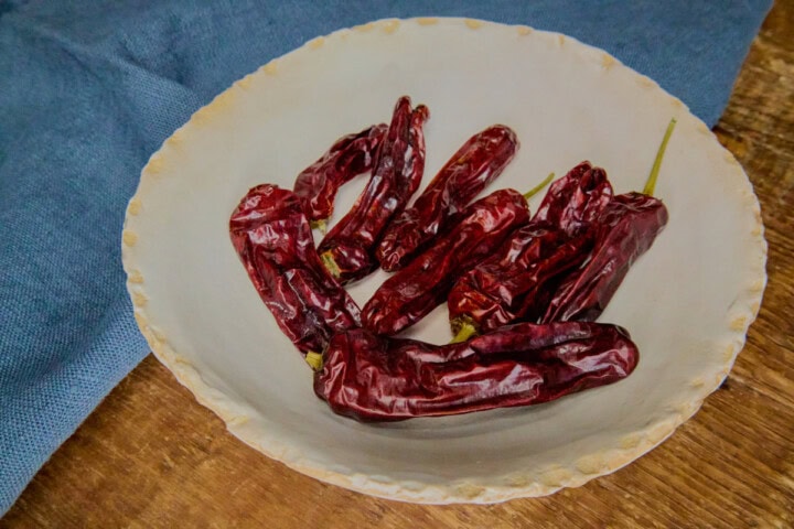 dried shisito peppers in a bowl with a napkin in the background