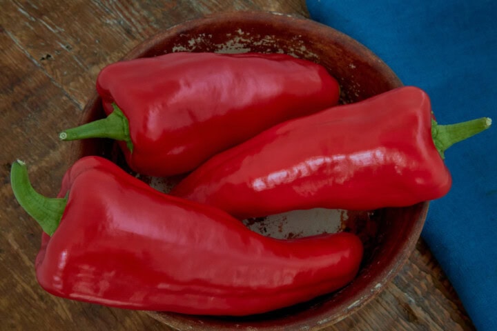 fresh giant aconagua peppers in a bowl with a napkin in the background