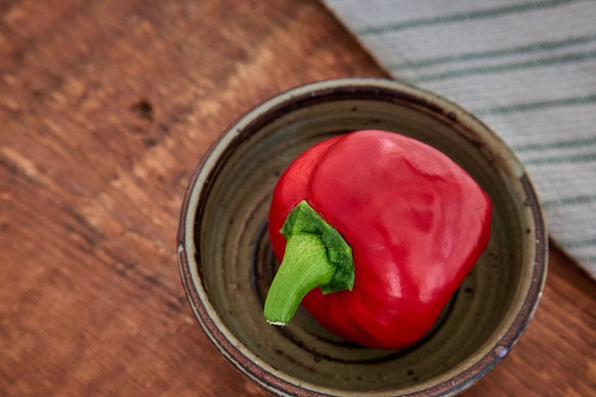 a fresh lesya pepper in a bowl with a kitchen towel in the background