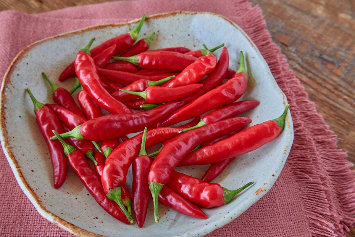 fresh piri piri peppers in a bowl atop a napkin