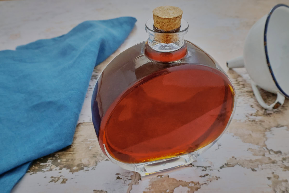 a bottle of lavender liqueur, napkin, and funnel