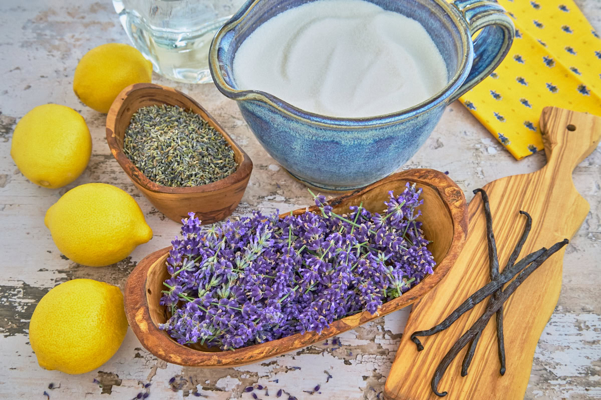 ingredients for lavender liqueur in containers and a napkin and wooden board