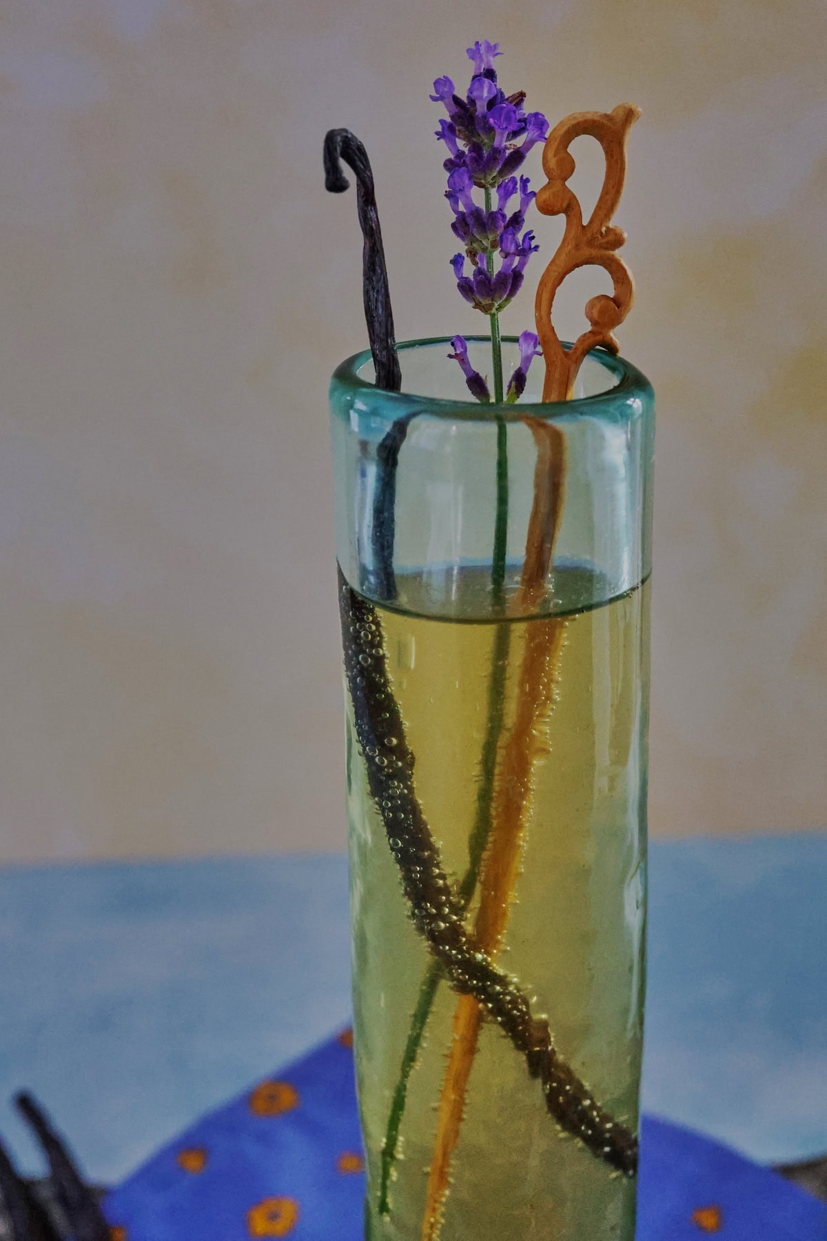 a cocktail in a champagne glass with a napkin and vanilla beans on a metal tray