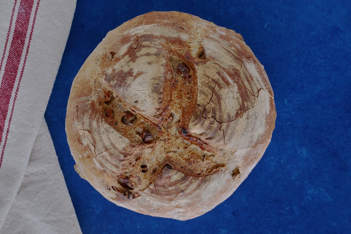 a round loaf of bread and a kitchen towel