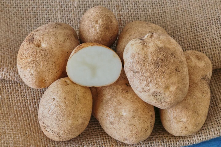 russet burbank potatoes on burlap on a background
