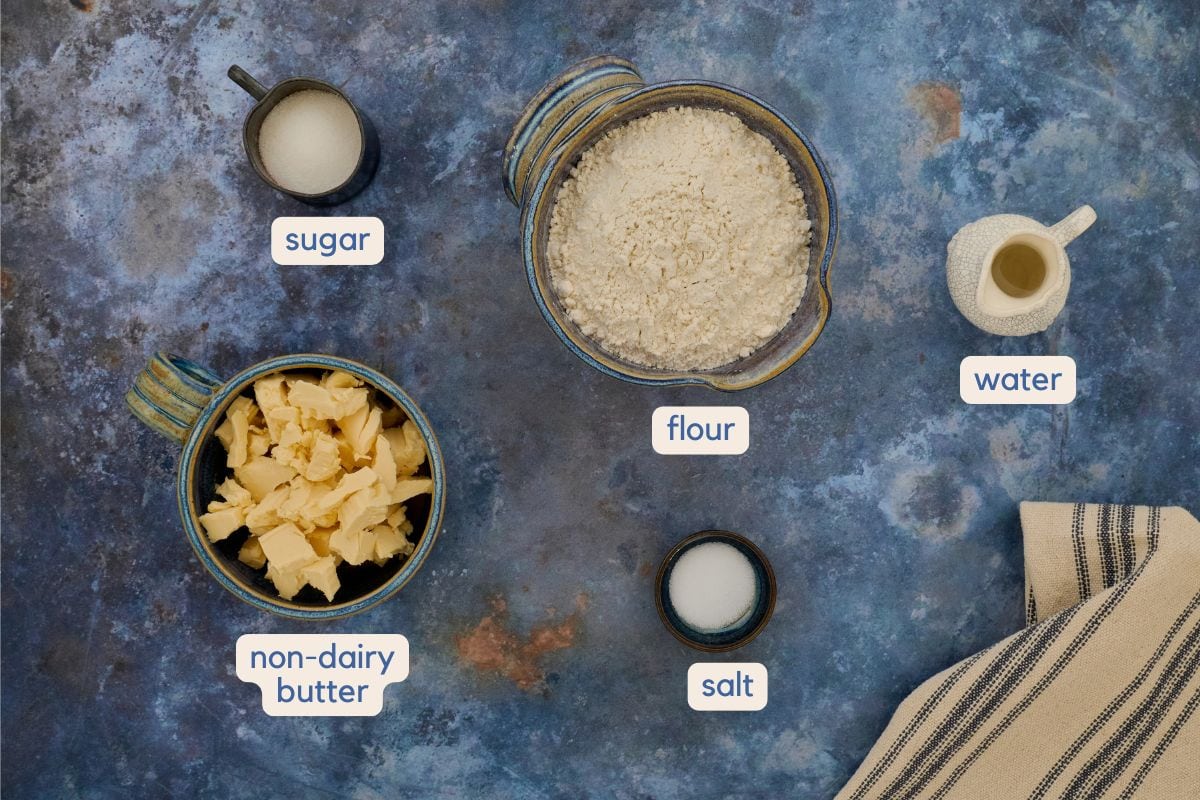 labeled walnut tart crust ingredients in bowls with a kitchen towel