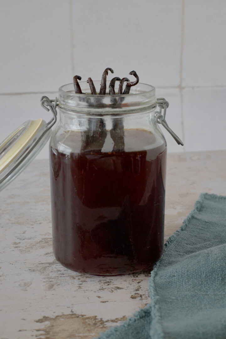 an open jar of liqueur and vanilla beans and a napkin