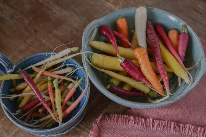 heirloom carrots in bowls with a napkin alongside
