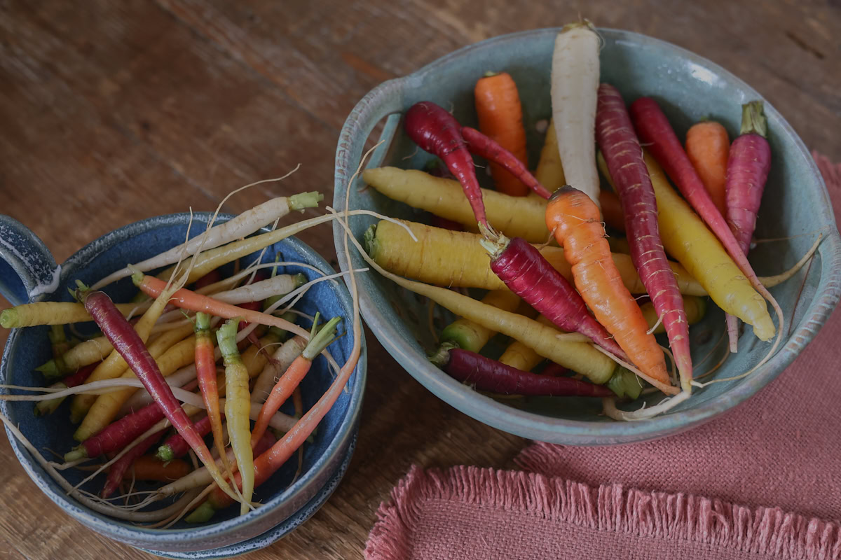 heirloom carrots in bowls with a napkin alongside