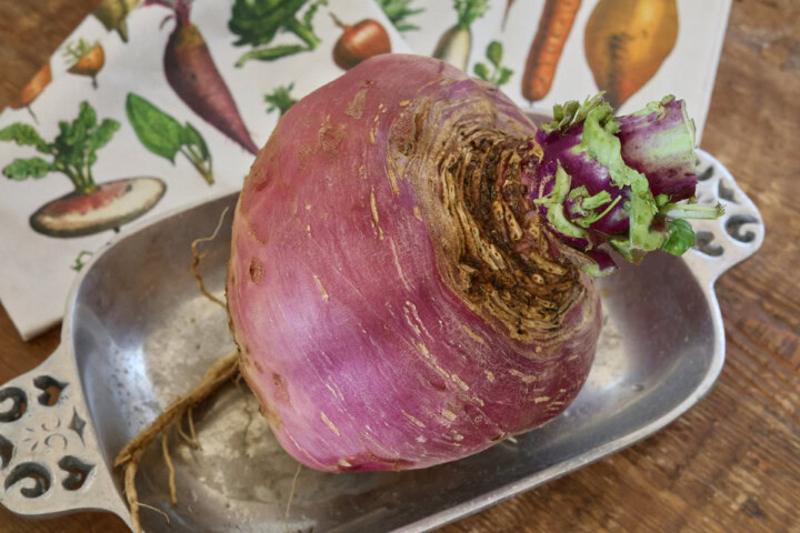 a marian rutabaga in a metal dish with a kitchen towel in the background