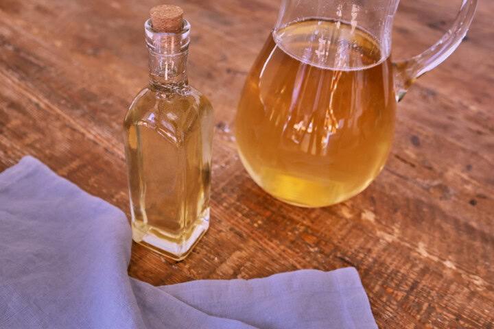 attar of roses simple syrup in a bottle and pitcher and a napkin